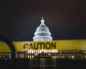 United States Capitol framed by caution tape, symbolising legislative gridlock during the government shutdown.
