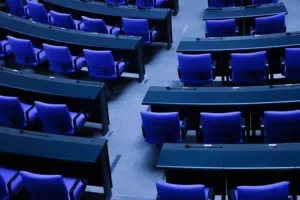 Empty blue plenary seats in the German Bundestag debating chamber inside the Reichstag building.