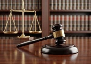 gavel-scales-justice-courtroom-setting-1-300x210.jpg