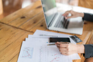 an-hand-with-financial-charts-laptop-table-300x200.jpg