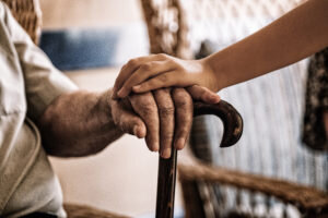 child-s-hand-old-man-s-hand-holding-cane-300x200.jpg